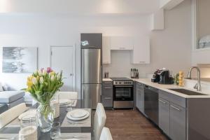 a kitchen with a table with a vase of flowers at Parc Avenue Residences Mile End in Montréal