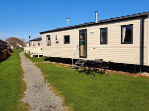 uma fila de casas móveis brancas sentadas na relva em Beachside caravan em Mablethorpe