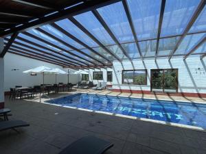 a large swimming pool with a large glass ceiling at cabañas Mazzatl jacuzzy in Mazamitla