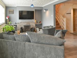 a living room with a couch and a fireplace at Breuddwydion Cymru welsh Dreams in Cemaes Bay