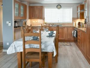 a kitchen with a wooden table with chairs and a dining room at Breuddwydion Cymru welsh Dreams in Cemaes Bay