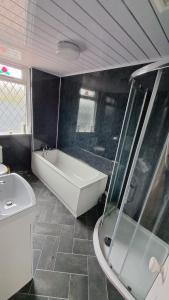 a bathroom with a bath tub and a sink at Beach & Tonic beachside chalet in Humberston