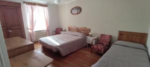1 dormitorio con 1 cama, 2 sillas y ventana en Appartamento San Francesco, en Cavizzana