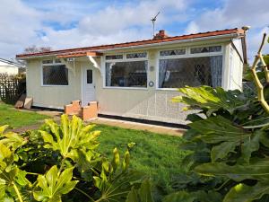 una pequeña casa en un patio con césped verde en Beach & Tonic beachside chalet, en Humberston