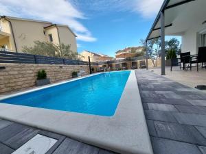 a swimming pool with blue water in a house at Apartmani Tropical in Vodice
