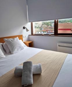 ein Schlafzimmer mit einem Bett und einem Handtuch darauf in der Unterkunft Apartamentos la Garita - Casa Juan yBlanca - Cudillero in Cudillero