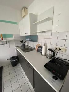 a kitchen with white cabinets and a black appliance on the counter at PS-Projektentwicklung in Dortmund