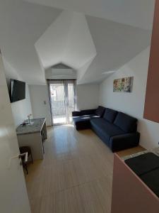 a living room with a blue couch and a table at Apartmani Tropical in Vodice