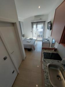 eine Küche mit einem Waschbecken und ein Bett in einem Zimmer in der Unterkunft Apartmani Tropical in Vodice