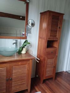 a bathroom with a sink and a wooden cabinet at Le Marronnier in Saint-Vincent-de-Pertignas