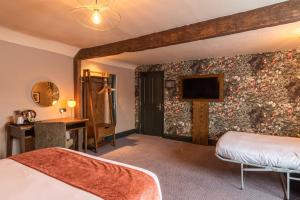 um quarto de hotel com uma cama e uma televisão na parede em The Bell by Innkeeper's Collection em Aston Clinton