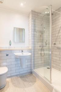 a white bathroom with a sink and a shower at The Bell by Innkeeper's Collection in Aston Clinton