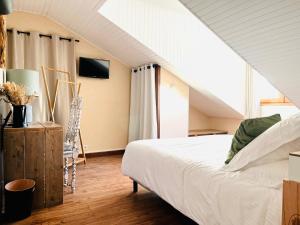 een slaapkamer met een wit bed op zolder bij Hôtel les Chaumettes in Savines