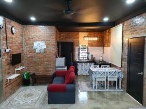 sala de estar con mesa y pared de ladrillo en Studio Amani Permatang Pauh, en Permatang Pauh