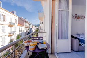 een balkon met een tafel met eten erop bij Cannes centre apartment with a balcony in Cannes