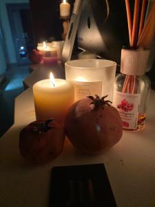 dos tomates y una vela sentada en una mesa en LUVIA ROOMS SPA, en Gonnesa