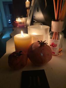 two tomatoes and a candle sitting on a table at LUVIA ROOMS SPA in Gonnesa