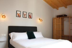 1 dormitorio con 2 camas blancas y armario de madera en XIMENETXE Vivienda Turística, en Santa Cruz de Campezo