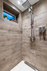 a bathroom with a shower with wooden walls at Ferienwohnung Blickfang am Nordberg in Goslar