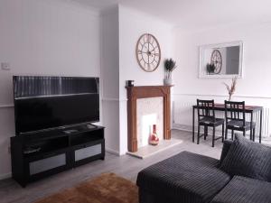 a living room with a couch and a television at Exquisite Two Bed Apartment in Grays - Free Wi-Fi and Netflix in Stifford
