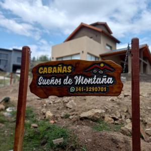 un cartel de madera frente a una casa en Sueños de Montaña en Villa Yacanto
