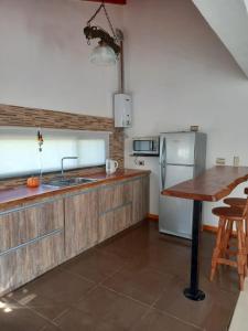 cocina con encimera de madera y mesa de madera en Sueños de Montaña en Villa Yacanto