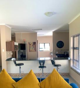a living room with blue chairs and a counter at Valleyside Executive Apartments in Ezulwini