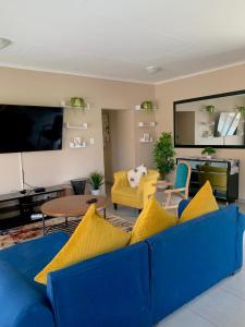 a living room with a blue couch and a yellow chair at Valleyside Executive Apartments in Ezulwini