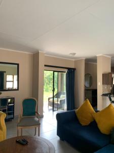 a living room with a blue couch and a table at Valleyside Executive Apartments in Ezulwini
