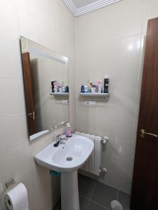 a bathroom with a sink and a mirror at Apartamento con terraza in Bádames +5 photos