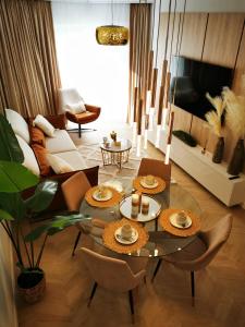 a living room with a glass table and chairs at Gold Apartment B29 Let's Sea Baltic Park Gąski in Gąski