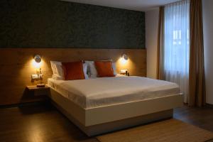 um quarto com uma cama grande e uma janela em Adler Schiltach Boutique Hotel und Restaurant em Schiltach