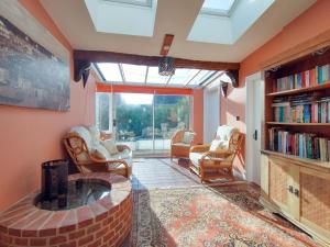 sala de estar con chimenea, sillas y estante para libros en Laburnham Cottage, en Stowmarket