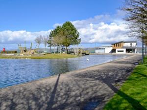 a body of water with a building in the background at Park View Cottage in Stranraer