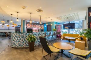 a restaurant with a bar with chairs and tables at Ibis Madrid Calle Alcalá in Madrid