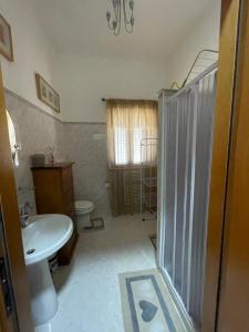 een badkamer met een douche, een wastafel en een toilet bij B&B Casa Mimì in San Ferdinando di Puglia
