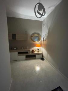 een kamer met een tafel, een lamp en een spiegel bij B&B Casa Mimì in San Ferdinando di Puglia