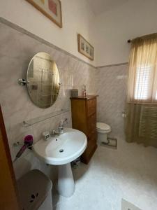 a bathroom with a sink and a mirror and a toilet at B&B Casa Mimì in San Ferdinando di Puglia