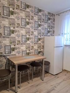 a dining room with a table and a refrigerator at APARTAMENT na STARÓWCE in Pasłęk