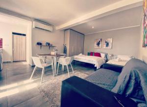 a bedroom with two beds and a table and chairs at Malta Suites in Senglea