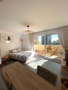 a bedroom with a bed and a large balcony at Luxueux Studio Neuf - Frontière Monaco - Piscine - Parking privé in Monte Carlo