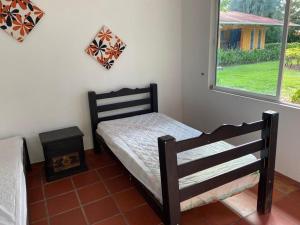 niewielka sypialnia z łóżkiem i oknem w obiekcie Finca Villa juanes w mieście Villavicencio