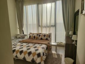 1 dormitorio con 1 cama frente a una ventana en FULLY FURNISHED 2BR APARTMENT WITH MAIDS ROOM B411 en Dubái