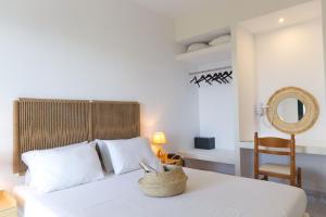 ein Schlafzimmer mit einem Bett mit einem Spiegel und einem Stuhl in der Unterkunft Koukounari Apartments in Skala