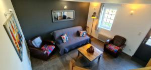 - un salon avec un canapé bleu et deux chaises dans l'établissement Maison normande, à Freneuse-sur-Risle