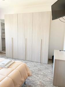 a white bedroom with a bed and a tv at B&B Casa degli Ulivi in Nettuno