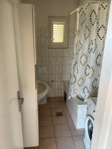 a bathroom with a tub and a shower curtain at Apartment Ivanka in Senj