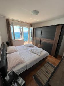 a bedroom with a large bed with a view of the ocean at Apartment Ivanka in Senj