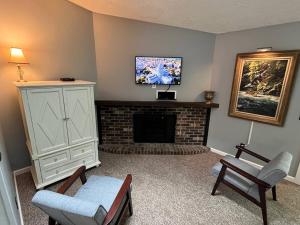 a living room with a tv and a fireplace at The Lakeside Eagle's Nest Near the Trail in Hurley