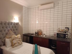 een hotelkamer met een bed en een magnetron bij Apartment A8 inside Bains Lodge in Bloemfontein